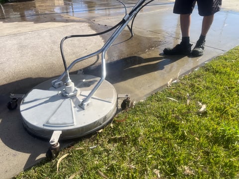 Concrete sidewalk walkway being pressure washed